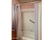 Modest bathtub and shower, showcasing classic fixtures and colorful striped shower curtains at 10102 E Michigan Ave, Sun Lakes, AZ 85248