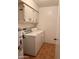 Bright laundry room with washer, dryer, cabinets, and tile flooring at 10102 E Michigan Ave, Sun Lakes, AZ 85248