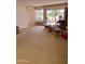 Spacious living room featuring carpet flooring and a large sliding glass door to the outdoors at 10102 E Michigan Ave, Sun Lakes, AZ 85248