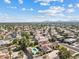 This aerial view features homes with mature landscaping, community parks, nearby schools, and mountain views at 10205 E Corrine Dr, Scottsdale, AZ 85260