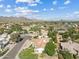 An aerial view captures this home with its clay tile roof and desert landscaping, nestled in a lush Phoenix community at 10205 E Corrine Dr, Scottsdale, AZ 85260