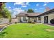 Manicured backyard with lush lawn, tiled patio, and a mature landscape design, perfect for outdoor relaxation and entertainment at 10205 E Corrine Dr, Scottsdale, AZ 85260