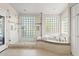 Bright bathroom features a luxurious tub, glass block windows and shower at 10205 E Corrine Dr, Scottsdale, AZ 85260
