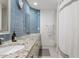 Bathroom featuring a double sink vanity, blue tile backsplash, and a shower-tub combo at 10205 E Corrine Dr, Scottsdale, AZ 85260