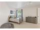 Well-lit bedroom featuring a gray bed frame, light colored walls, and neutral carpet at 10205 E Corrine Dr, Scottsdale, AZ 85260