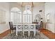 A spacious dining room features a chandelier, white shutters, wood floors, and a gray rug at 10205 E Corrine Dr, Scottsdale, AZ 85260