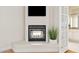 Living room fireplace with decorative plant and doorway to bathroom at 10205 E Corrine Dr, Scottsdale, AZ 85260