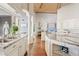 Open kitchen layout showcasing granite countertops, white cabinetry, and wood flooring at 10205 E Corrine Dr, Scottsdale, AZ 85260