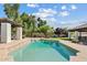 Backyard view of a sparkling in-ground pool, green grass, and beautiful landscaping at 10205 E Corrine Dr, Scottsdale, AZ 85260