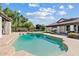 Backyard view of a beautiful in-ground pool, lush greenery, and a playset at 10205 E Corrine Dr, Scottsdale, AZ 85260
