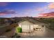 Desert home backyard with dining and landscaping at dusk, showcasing outdoor living at 10607 E Hillside Mine Ct, Gold Canyon, AZ 85118