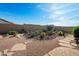 Expansive backyard featuring desert landscaping, gravel, cacti, and decorative stone pavers at 10607 E Hillside Mine Ct, Gold Canyon, AZ 85118