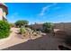 Spacious backyard featuring low-maintenance landscaping with a charming doghouse and blooming Oleander at 10607 E Hillside Mine Ct, Gold Canyon, AZ 85118