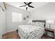 This bright bedroom features wood-look floors, a ceiling fan, and a window overlooking the side yard at 10607 E Hillside Mine Ct, Gold Canyon, AZ 85118