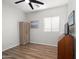 This bedroom features wood-look floors, ceiling fan, a closet, and a window overlooking the side yard at 10607 E Hillside Mine Ct, Gold Canyon, AZ 85118