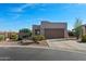 Charming home featuring low-maintenance desert landscaping, a paved driveway, and an attached two-car garage at 10607 E Hillside Mine Ct, Gold Canyon, AZ 85118