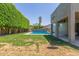 Expansive backyard features a sparkling pool, green lawn, and mature privacy hedges at 12813 S 38Th St, Phoenix, AZ 85044