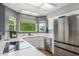 Updated kitchen boasts stainless steel appliances, white cabinets, quartz counters, and a window with a view at 12813 S 38Th St, Phoenix, AZ 85044