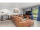 Spacious living room showcasing a leather sectional couch, tile floors, and a sliding glass door at 12813 S 38Th St, Phoenix, AZ 85044