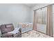 Cozy bedroom with plush carpeting, crib, window, and chair at 17891 W Badger Way, Goodyear, AZ 85338
