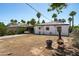 Expansive backyard showcasing the house's exterior and outdoor patio area surrounded by lush palm trees at 2041 N 16Th Ave, Phoenix, AZ 85007
