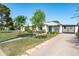 Desirable single-story home with a well-manicured lawn, mature trees, and a spacious driveway at 2041 N 16Th Ave, Phoenix, AZ 85007