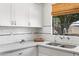Bright kitchen featuring white cabinets, quartz countertops, and a sink with a garden view at 2041 N 16Th Ave, Phoenix, AZ 85007