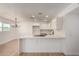Open concept kitchen with white cabinets, island cooktop, and modern lighting at 2443 E Randall Dr, Tempe, AZ 85288