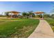 Community playground featuring covered play structures and lush green space, ideal for families and outdoor activities at 2519 E Fortana Dr, San Tan Valley, AZ 85143