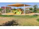 Community playground with colorful equipment, shade structure, and ample green space for children to play and enjoy at 2519 E Fortana Dr, San Tan Valley, AZ 85143
