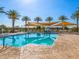 Gathering friendly community pool with splash pad, sunshade canopies, lounge chairs, and many palm trees at 2591 E Fortana Dr, San Tan Valley, AZ 85143