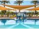 Gathering friendly community pool with splash pad and sunshade canopies surrounded by lounge chairs and palm trees at 2591 E Fortana Dr, San Tan Valley, AZ 85143
