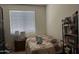 Bedroom with a bed, window with blinds, bedside table, and bookshelf at 25931 W Deer Valley Rd, Buckeye, AZ 85396