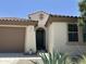 Close up of a home entrance with a dark green front door, desert plants, and an arched portico at 25931 W Deer Valley Rd, Buckeye, AZ 85396
