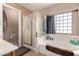 Bright bathroom with glass block window, soaking tub, and tiled floors at 298 W Dana Dr, San Tan Valley, AZ 85143