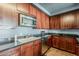 This kitchen features stainless steel appliances, dark cabinetry, and sleek granite countertops at 310 S 4Th St # 1601, Phoenix, AZ 85004