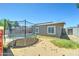 Large trampoline on a flat, sandy backyard under a bright sky next to a detached home with windows at 3107 W Lisbon Ln, Phoenix, AZ 85053