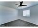 Bright bedroom with a ceiling fan, neutral carpet, and a window providing ample natural light at 3107 W Lisbon Ln, Phoenix, AZ 85053