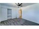 Comfortable bedroom featuring a ceiling fan, built-in closet shelving, and neutral carpet at 3107 W Lisbon Ln, Phoenix, AZ 85053