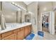 Well-lit bathroom with a double sink vanity, large mirror, and access to the walk-in closet at 3131 E Legacy Dr # 1032, Phoenix, AZ 85042