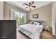 Inviting bedroom with a large window, plantation shutters, and a ceiling fan at 3131 E Legacy Dr # 1032, Phoenix, AZ 85042