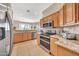 Modern kitchen featuring granite countertops, stainless steel appliances, and a view to the dining area at 3131 E Legacy Dr # 1032, Phoenix, AZ 85042
