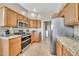 Bright kitchen with stainless steel appliances, granite countertops, and a view to the laundry area at 3131 E Legacy Dr # 1032, Phoenix, AZ 85042