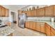 Functional kitchen with stainless steel refrigerator, granite counters, and plentiful wood cabinetry at 3131 E Legacy Dr # 1032, Phoenix, AZ 85042