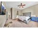 Spacious main bedroom featuring plush carpet, a tufted headboard, and a ceiling fan at 3131 E Legacy Dr # 1032, Phoenix, AZ 85042