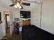 A cozy bedroom with a ceiling fan and a TV mounted on the wall at 3330 E Main St # 121, Mesa, AZ 85213