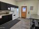 Bright community kitchen with white appliances, black cabinets, and convenient stainless-steel countertops at 3330 E Main St # 121, Mesa, AZ 85213