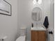 Modern powder room featuring a sleek vanity, round mirror, and contemporary fixtures at 3523 E Alfalfa Dr, Gilbert, AZ 85298