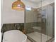 Luxurious bathroom with a freestanding tub, glass shower, and stylish woven light fixture at 3523 E Alfalfa Dr, Gilbert, AZ 85298