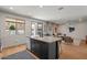 Modern kitchen featuring island seating, stainless appliances, sleek finishes, and a view of the living room and pool at 3523 E Alfalfa Dr, Gilbert, AZ 85298